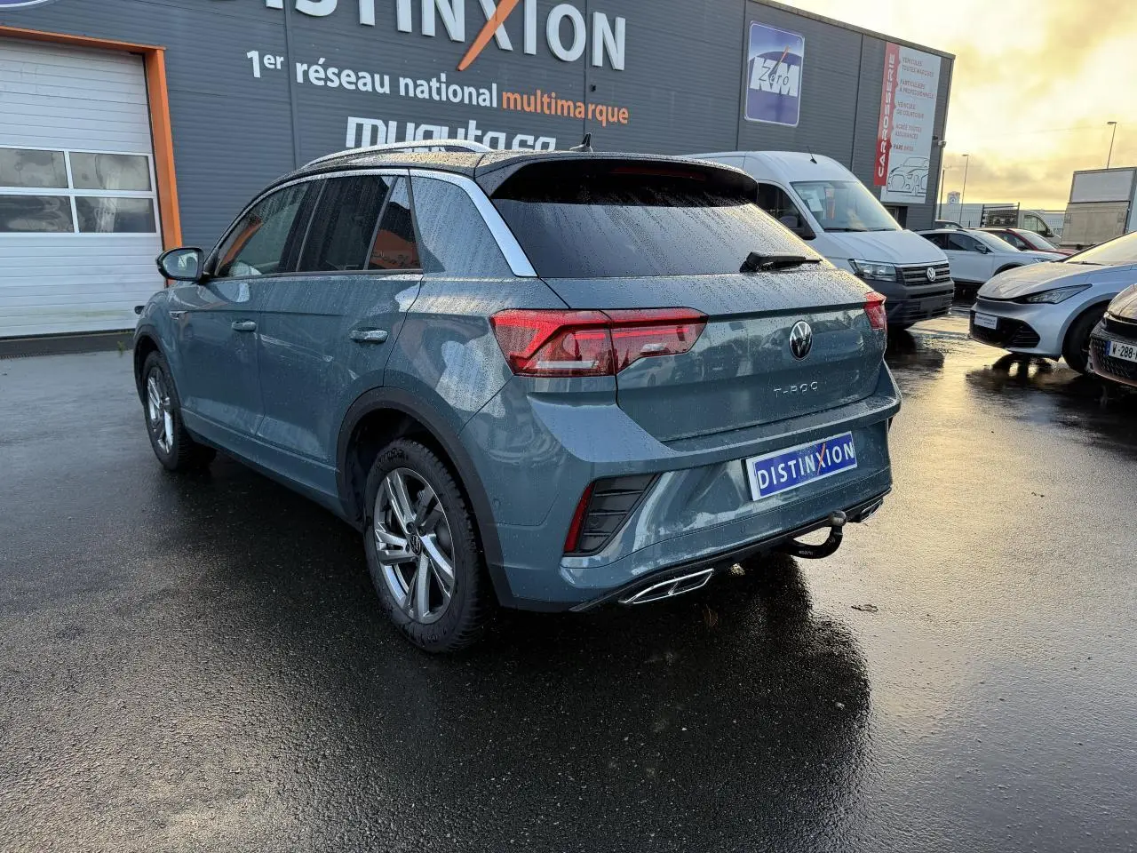 Volkswagen T-Roc bleu pétrole métallisé vu en 3/4 arrière droit avec attelage amovible et jantes Valencia gris galvanisé.