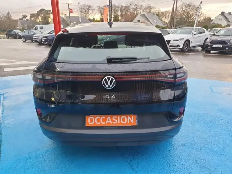 Vue arrière d'un Volkswagen ID.4 noir ébène métallisé avec feux LED reliés par une bande lumineuse rouge.