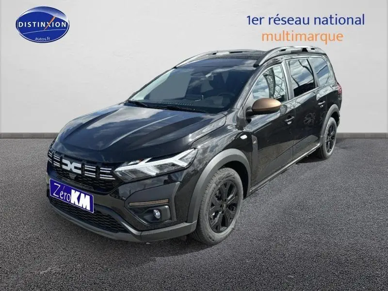 Vue 3/4 avant droite du Dacia Jogger noir nacré métallisé avec jantes noires et barres de toit visibles.