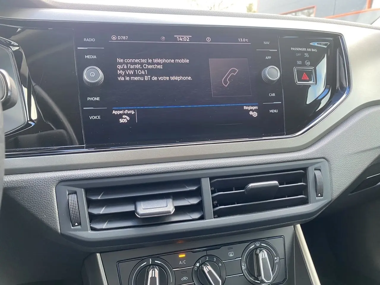 Vue rapprochée de la console centrale de la Volkswagen Polo 2020, écran tactile et commandes de climatisation visibles.
