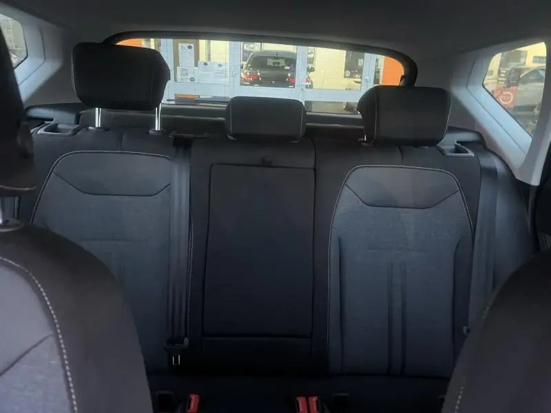 Vue intérieure arrière du SEAT Ateca 2022 noir, montrant la banquette arrière en tissu noir avec appuie-têtes et ceintures de sécurité.