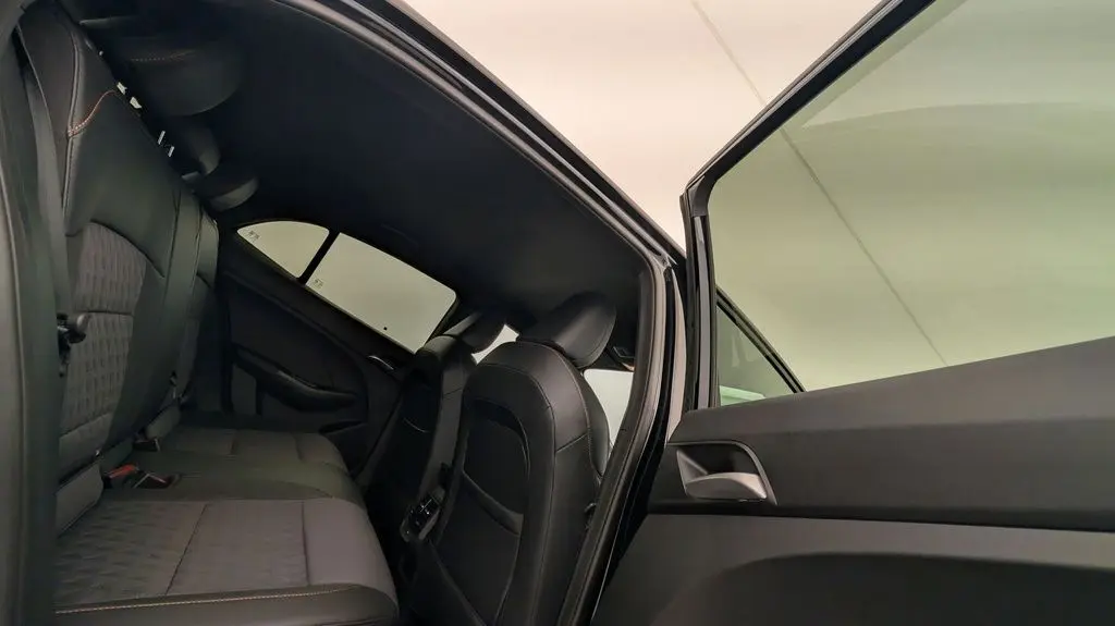 Vue intérieure côté gauche montrant les sièges arrière en similicuir noir avec surpiqûres orange du MG3 Pebble Black 2026.