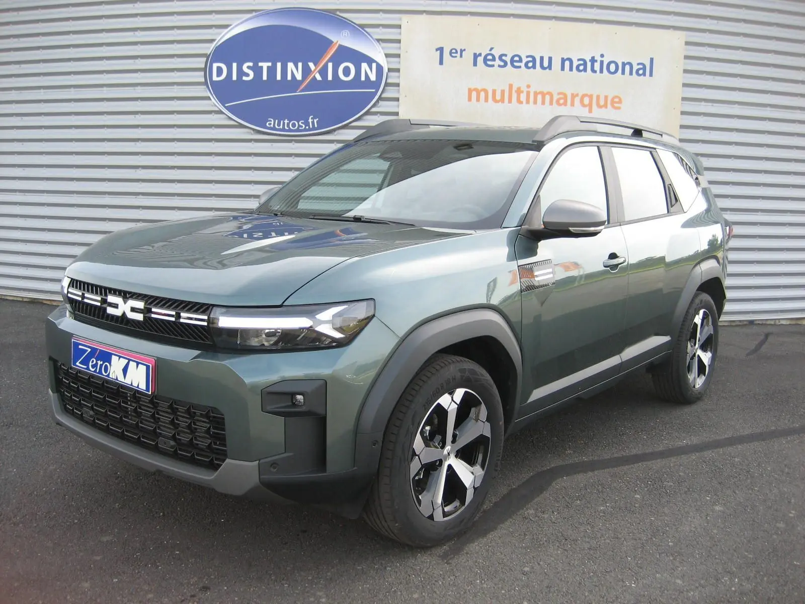 Dacia Bigster gris schiste en 3/4 avant droit, SUV hybride avec calandre noire et jantes modernes.