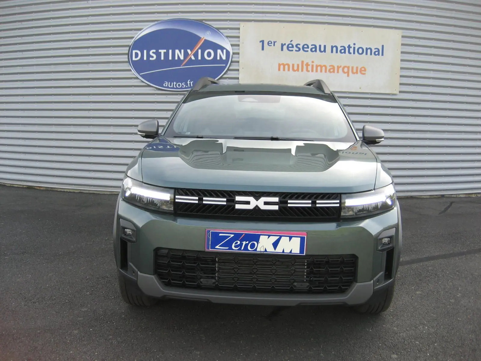 Vue de face du Dacia Bigster gris schiste 2026 avec calandre noire et phares LED allumés.