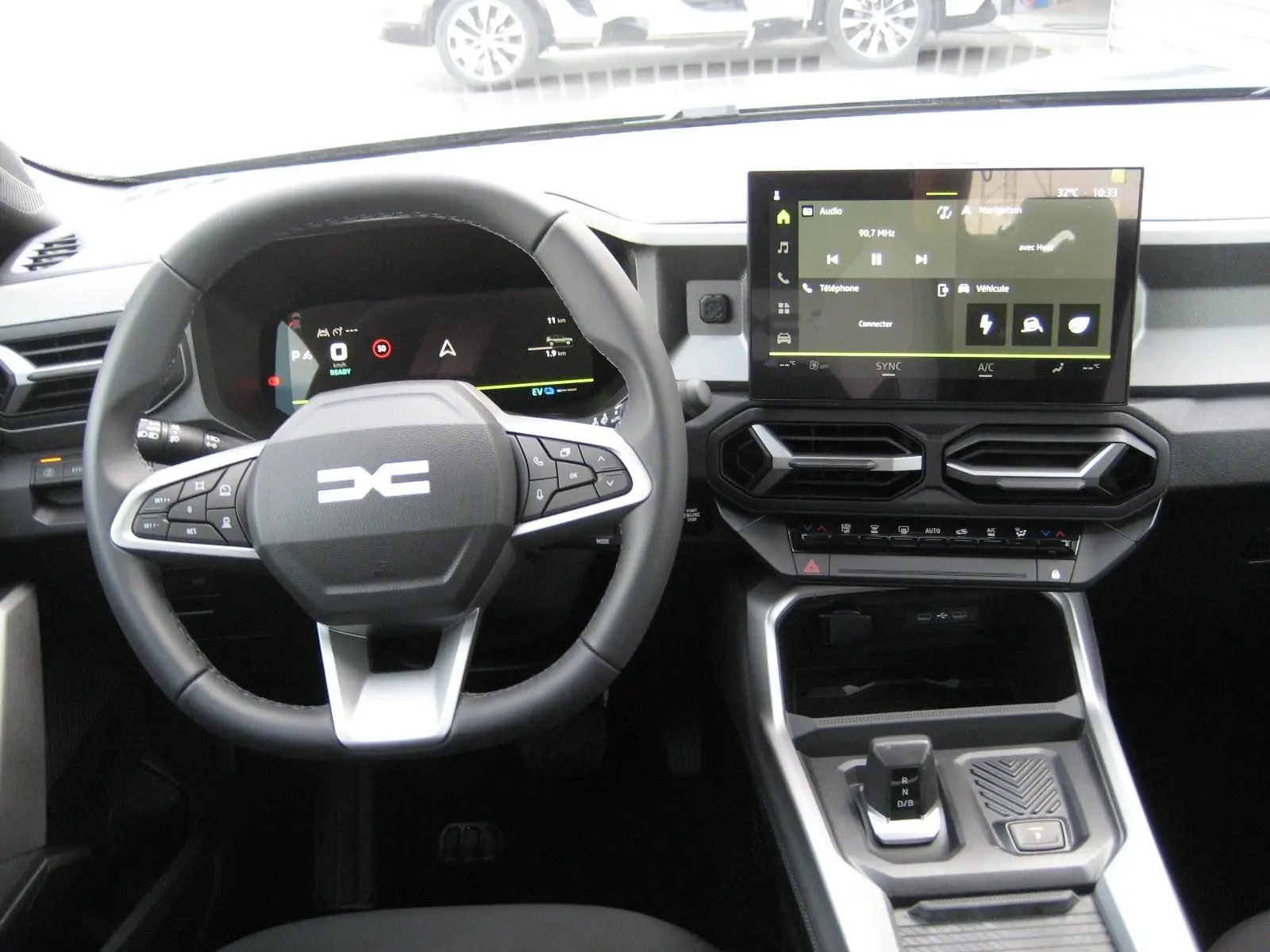 Vue intérieure rapprochée des sièges avant gris clair et foncé du Dacia Bigster 2026 avec logo brodé sur les appuie-têtes.
