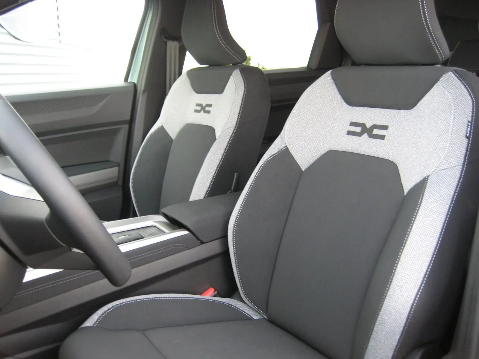 Vue intérieure centrée sur le volant et la console centrale du Dacia Bigster 2026, avec écran tactile et commandes modernes.
