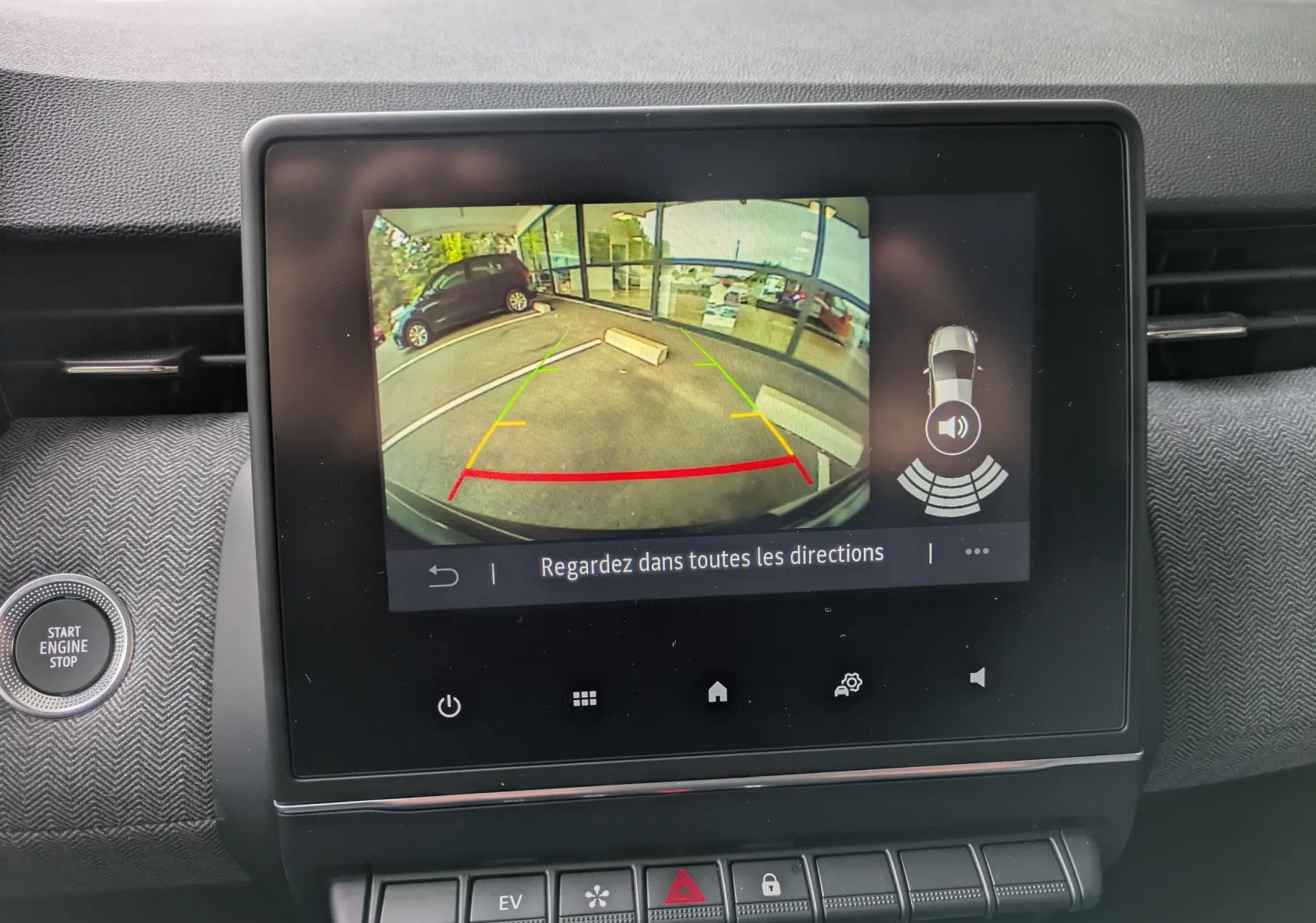 Écran central montrant la caméra de recul avec vue arrière du parking, dans une Renault Clio noire étoile métal 2025.
