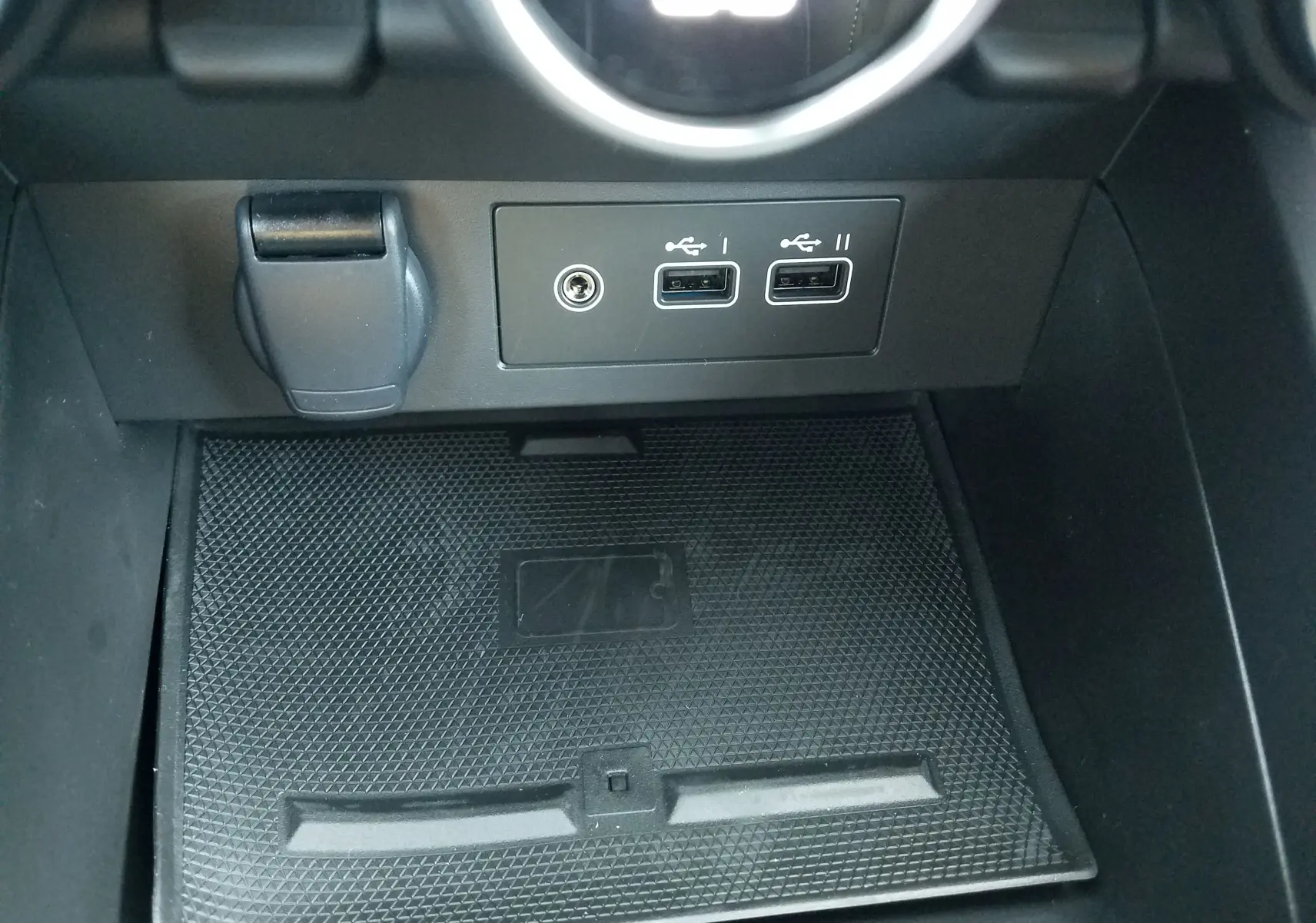 Gros plan sur la console centrale de la Renault Clio V gris Rafale, montrant les ports USB et un espace de rangement.