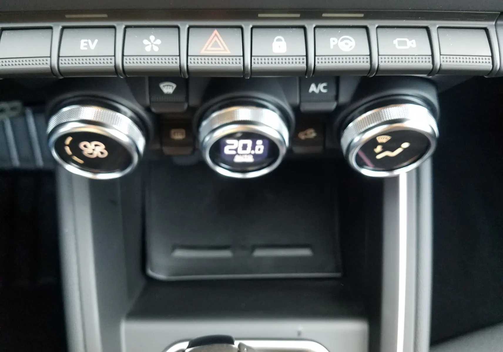 Gros plan sur les commandes de climatisation et les boutons de fonction du tableau de bord de la Renault Clio V hybride.