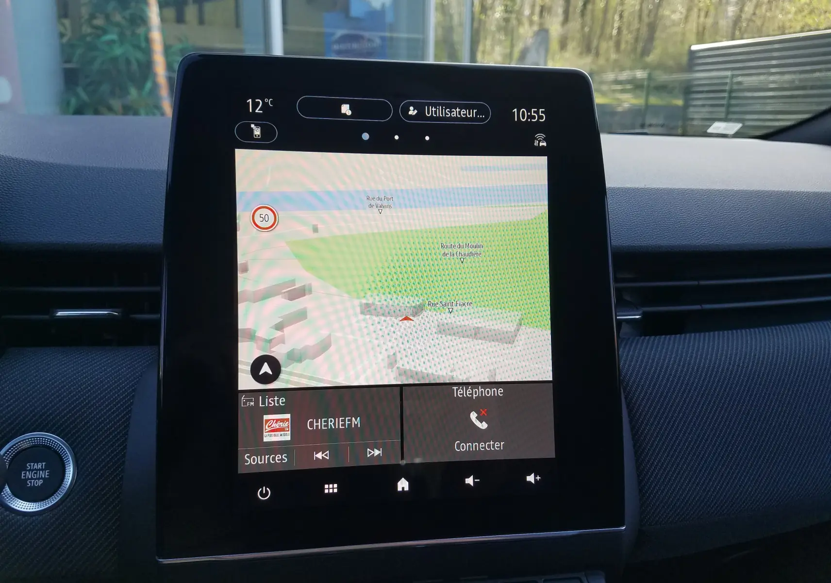 Écran tactile central du tableau de bord de la Renault Clio V gris Rafale, affichant la navigation et la radio.