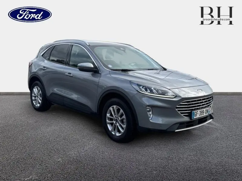 Ford Kuga gris Solar métallisé vue 3/4 avant droit avec calandre chromée et jantes alu.