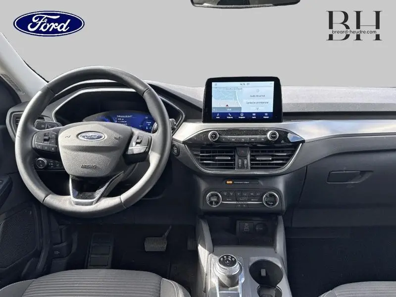 Vue intérieure avant du tableau de bord et volant cuir multifonction du Ford Kuga 2022 avec écran tactile et console centrale moderne.