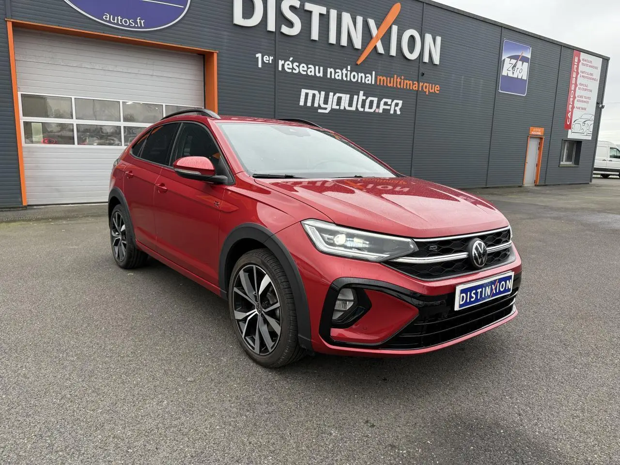 Volkswagen Taigo Rouge Roi en 3/4 avant droit, avec jantes noires brillantes et calandre R-Line distinctive.