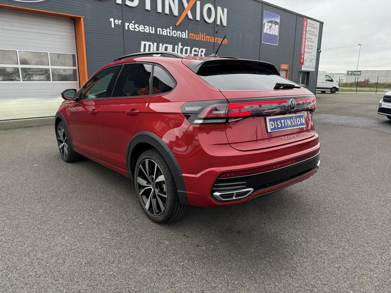 Volkswagen Taigo Rouge Roi vue 3/4 arrière droit, jantes noires brillantes et vitres surteintées.