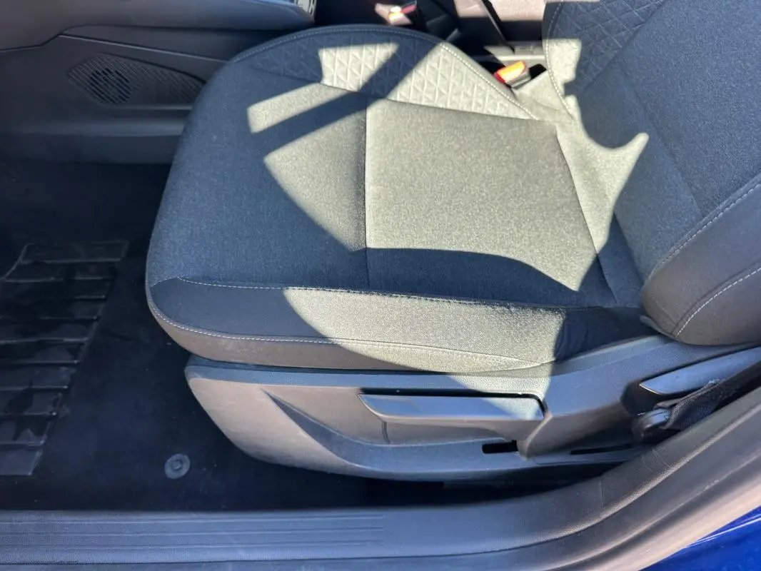 Gros plan sur le siège conducteur en tissu gris foncé de la Renault Clio V TCe 90 Equilibre 2023, côté gauche.