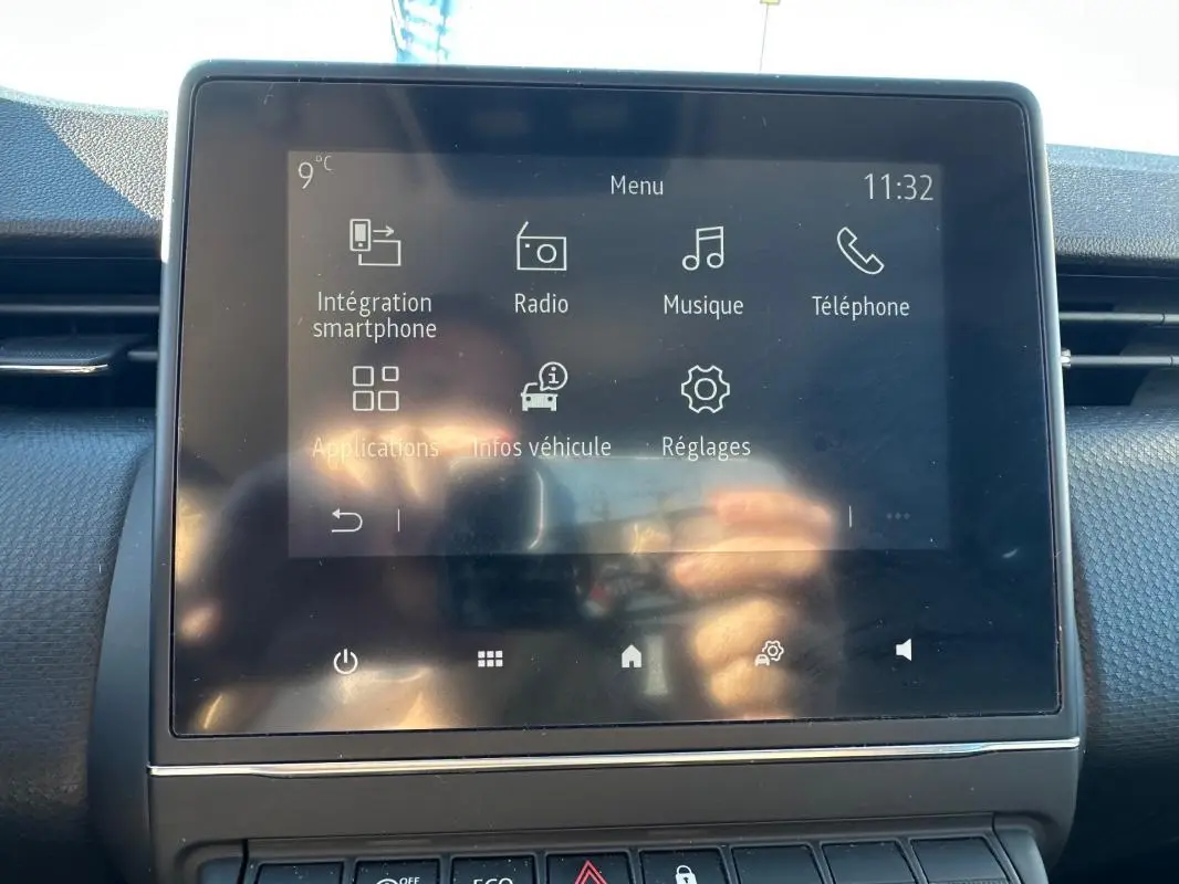 Écran tactile central de la Renault Clio bleu foncé 2023 affichant le menu multimédia intérieur.