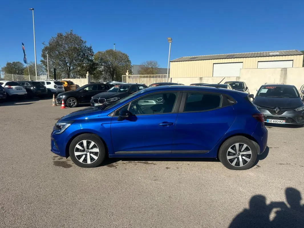 Profil côté gauche d'une Renault Clio bleu foncé 2023, compacte avec antenne requin et jantes modernes.