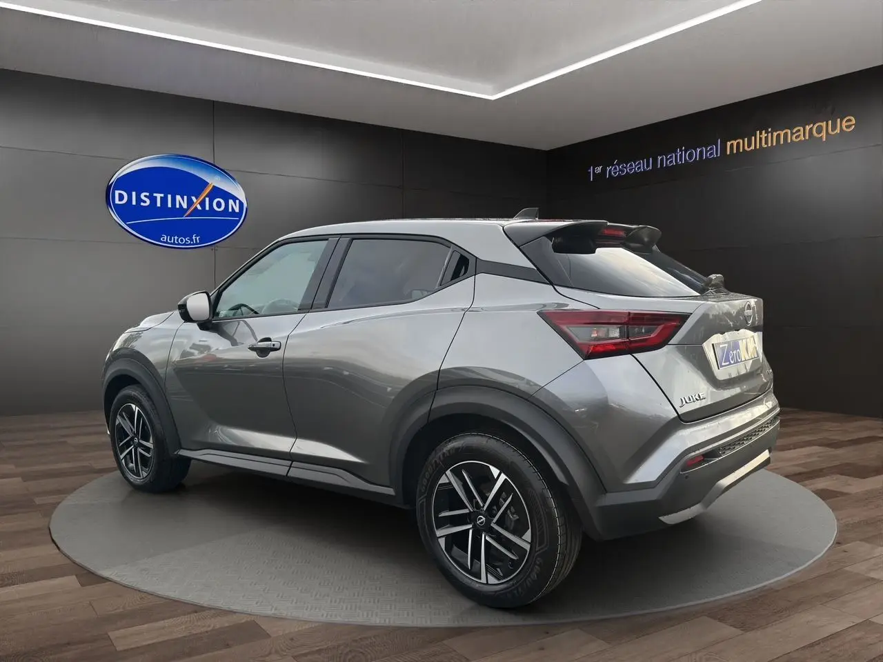 Vue 3/4 arrière droite du Nissan Juke 1.6 Hybrid 2025 en gris squale avec jantes alliage et toit noir contrasté.