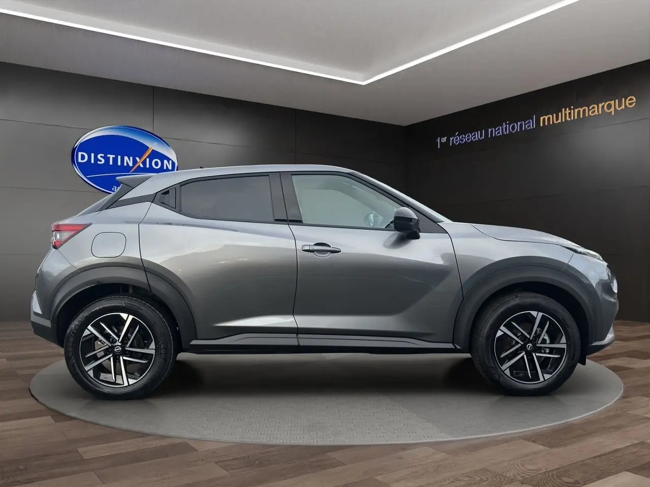 Vue de profil côté droit du Nissan Juke 2025 gris squale avec jantes alliage noires et détails noirs contrastants.