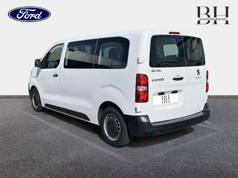 Vue 3/4 arrière droit d’un Peugeot Expert Fourgon blanc banquise avec vitres latérales teintées et portes arrière battantes.