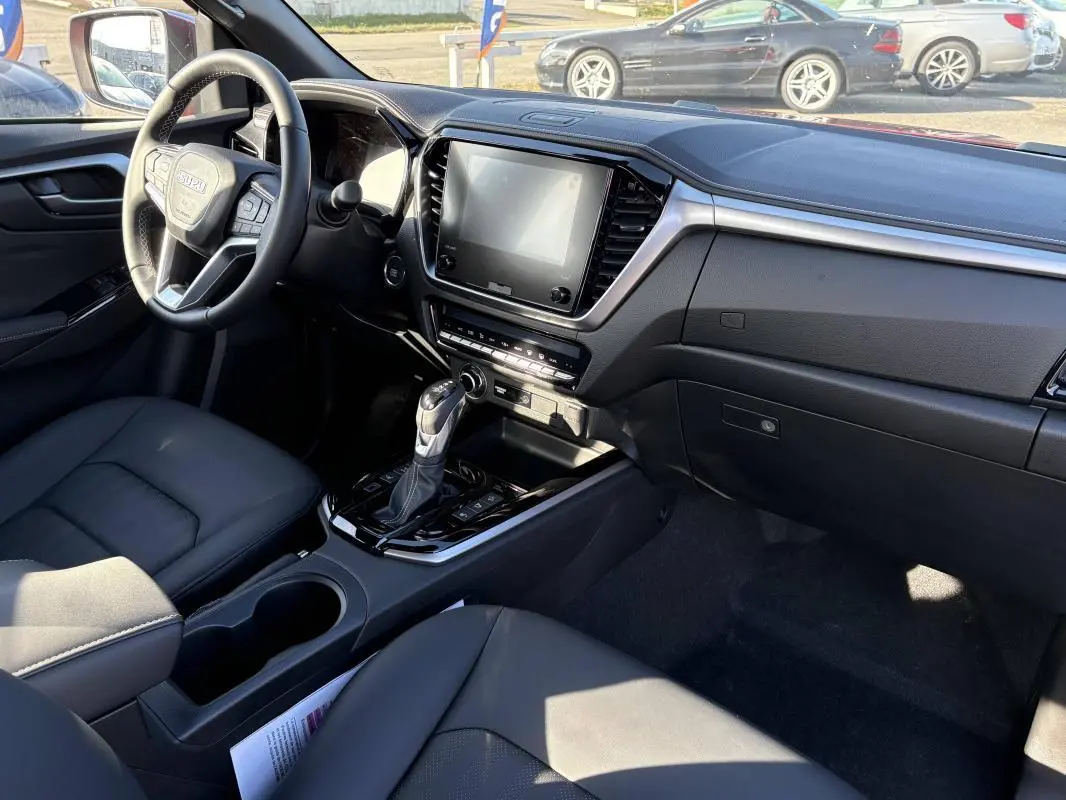 Intérieur du pick-up Isuzu D-MAX 2026, vue côté conducteur, tableau de bord moderne avec écran tactile et volant multifonctions.