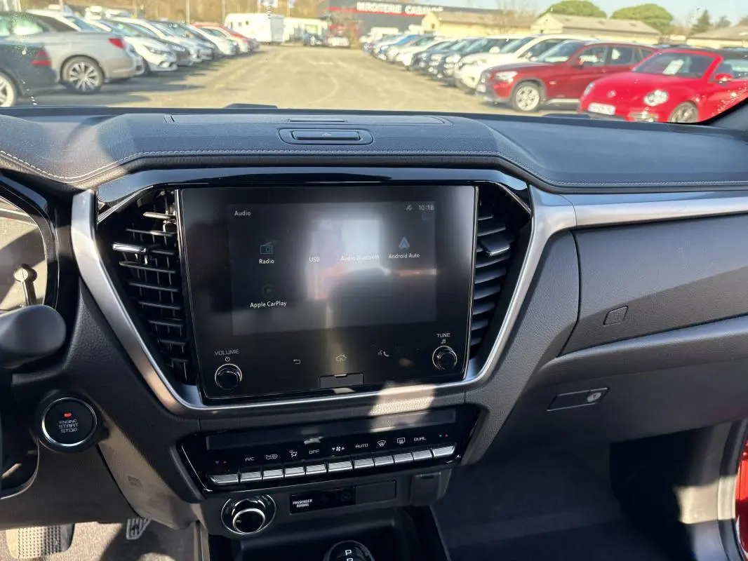 Vue intérieure centrée sur l’écran tactile et la console du tableau de bord du pick-up Isuzu D-MAX 2026.