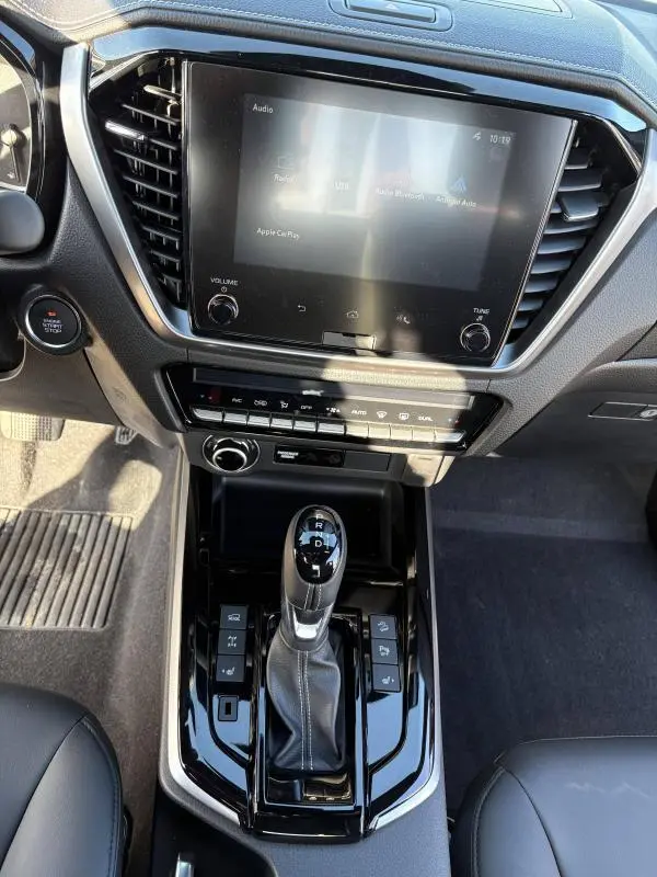 Vue rapprochée de la console centrale noire de l'Isuzu D-MAX 2026 avec écran tactile et levier de boîte automatique.