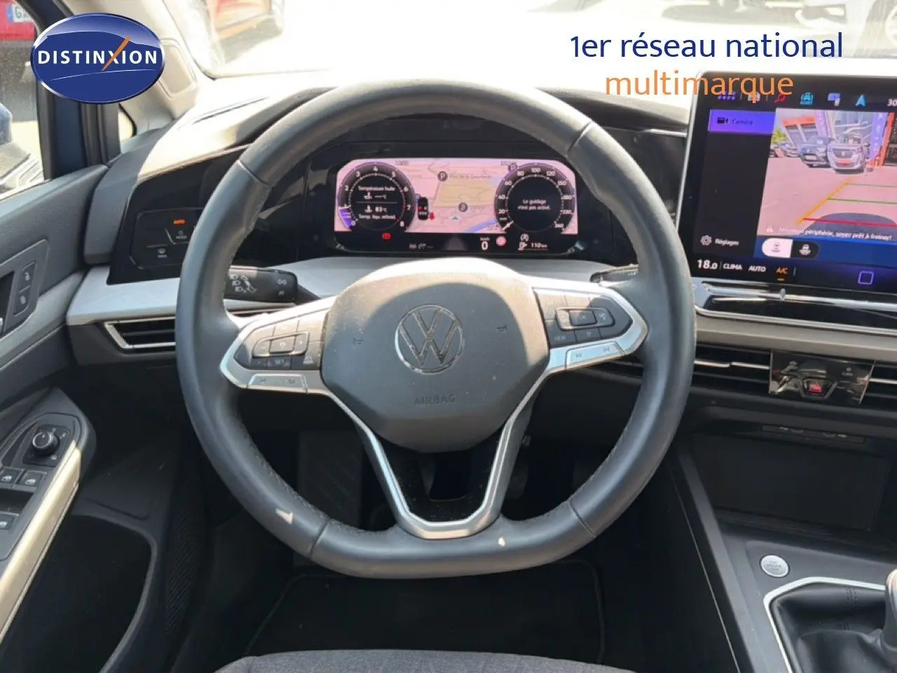 Vue intérieure centrée sur le volant et le tableau de bord numérique d'une Volkswagen Golf SW 2026, avec écran tactile et commandes au volant.