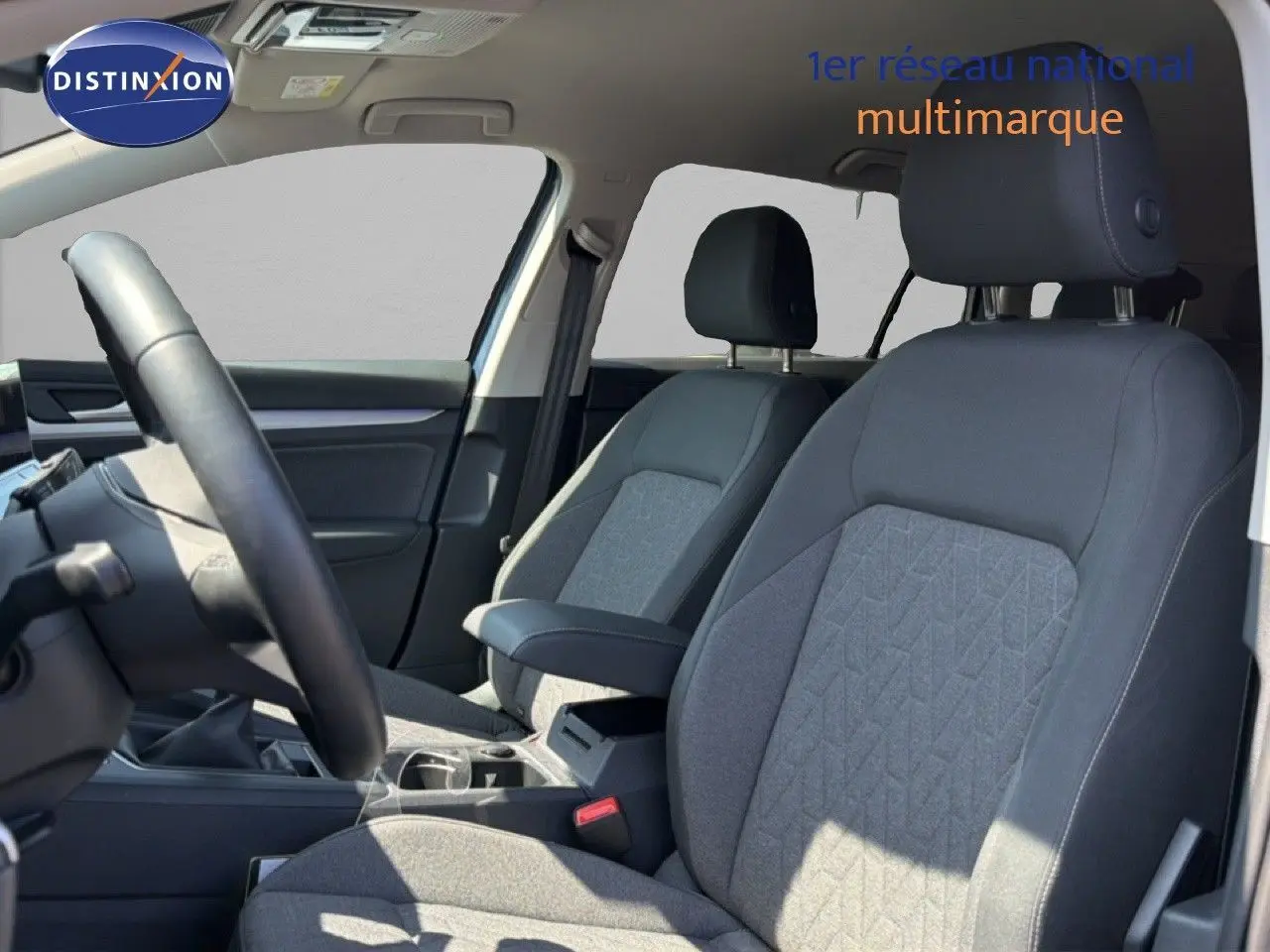Vue intérieure côté conducteur de la Volkswagen Golf SW 1.5 TSI Evo2 avec sièges tissu gris et volant noir.