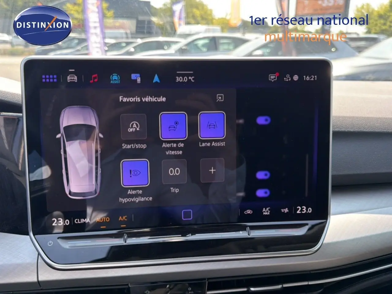 Écran tactile central affichant les options d'assistance à la conduite dans une Volkswagen Golf SW bleu Anemone.