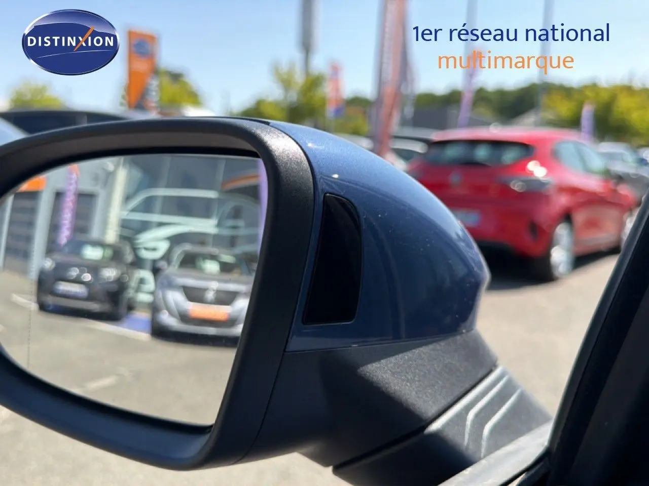 Rétroviseur côté gauche bleu Anemone de la Volkswagen Golf SW 2026, avec reflet de voitures en arrière-plan.