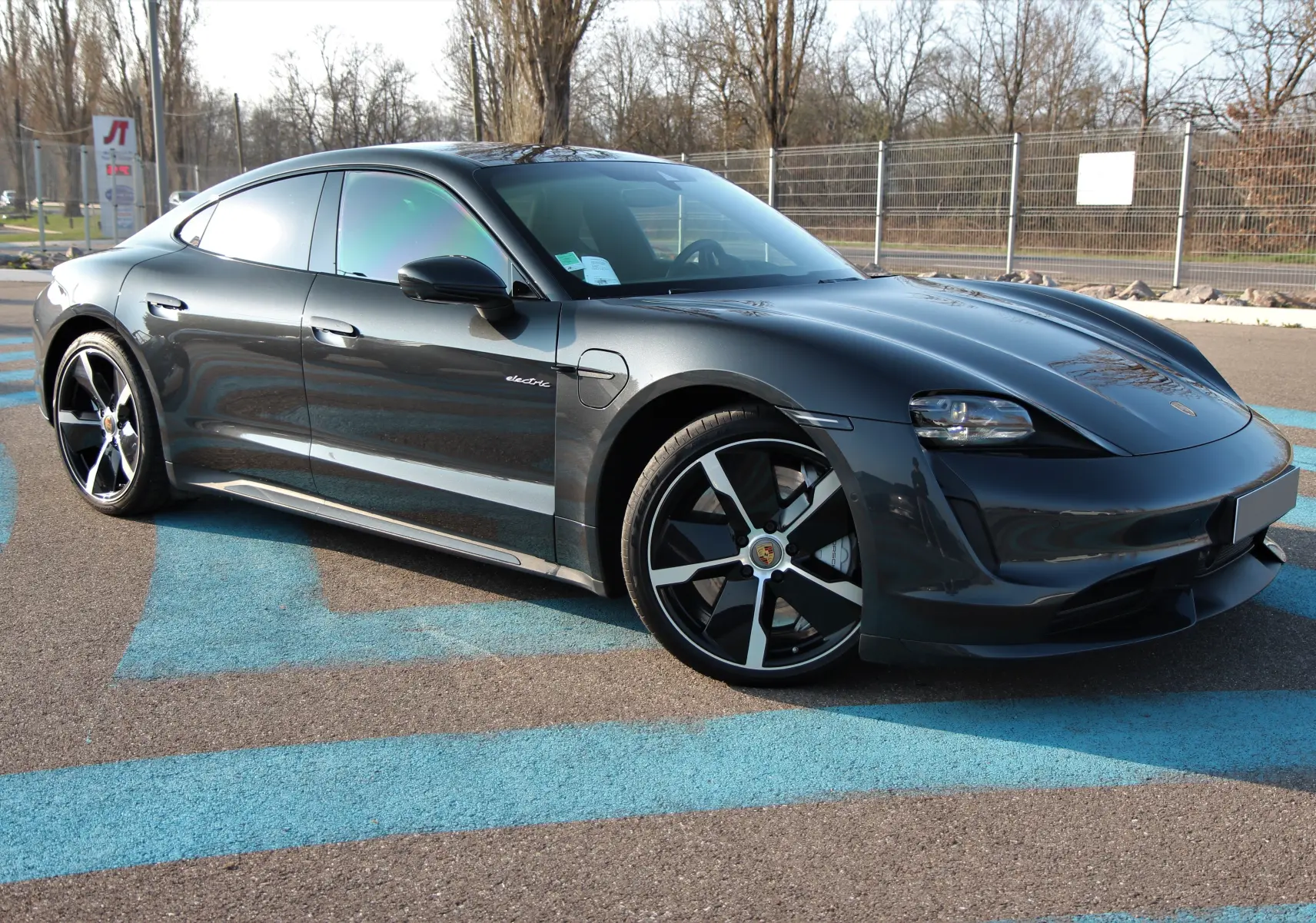Porsche Taycan Turbo gris anthracite vue 3/4 avant droit, avec jantes exclusives 21 pouces et toit panoramique.
