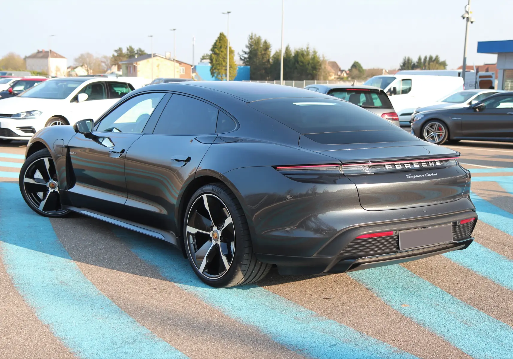 Porsche Taycan Turbo gris anthracite vue 3/4 arrière droit avec jantes exclusives et toit panoramique.