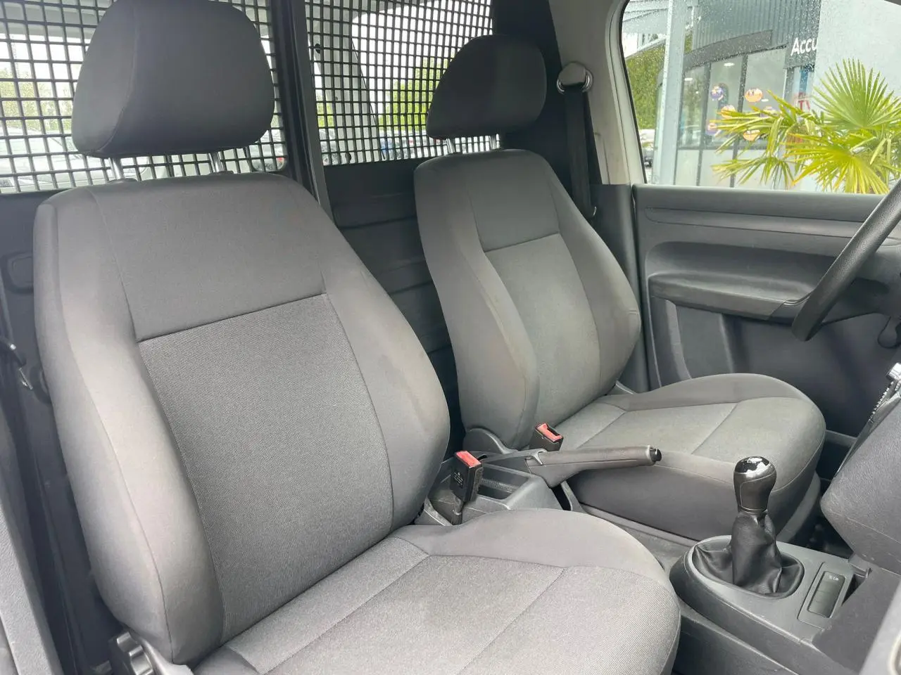 Intérieur du Volkswagen Caddy Van 2014 montrant les sièges avant gris et la boîte manuelle côté droit.