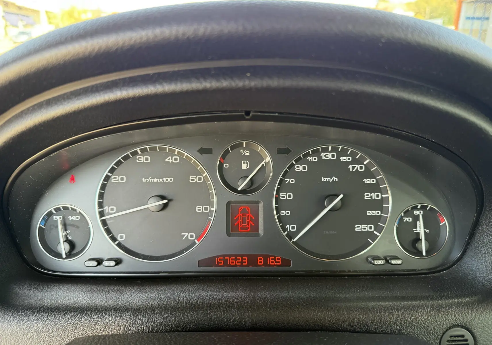 Tableau de bord de Peugeot 607 gris, affichant compteurs et jauge de carburant en gros plan.