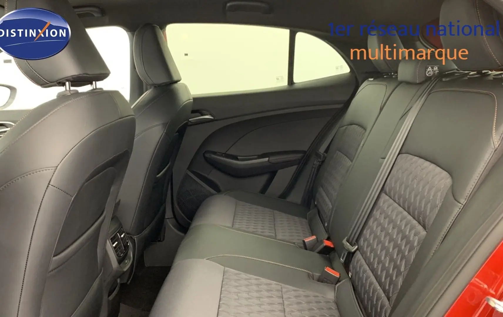 Vue intérieure arrière du siège arrière en similicuir noir de la MG3 1.5 L Hybrid+ Diamond Red, avec portières ouvertes.