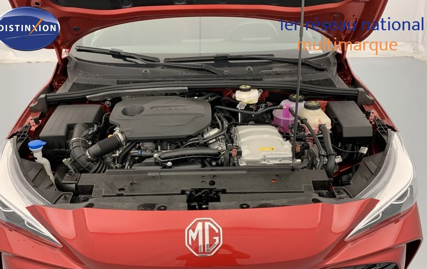 Moteur hybride visible sous le capot ouvert d'une MG3 1.5 L Hybrid+ Diamond Red vue de face.