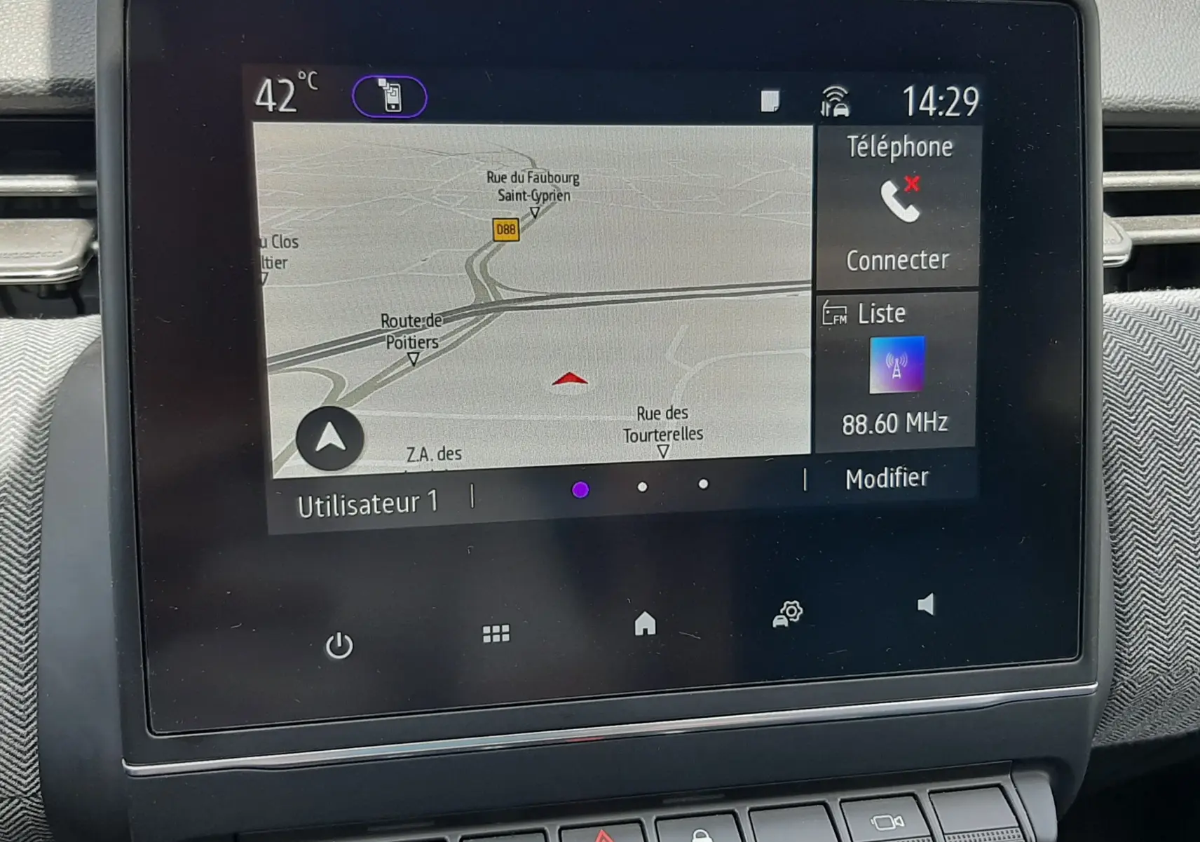 Écran tactile central de la Renault Clio V E-Tech, affichant la navigation et les commandes multimédia, intérieur gris noir.