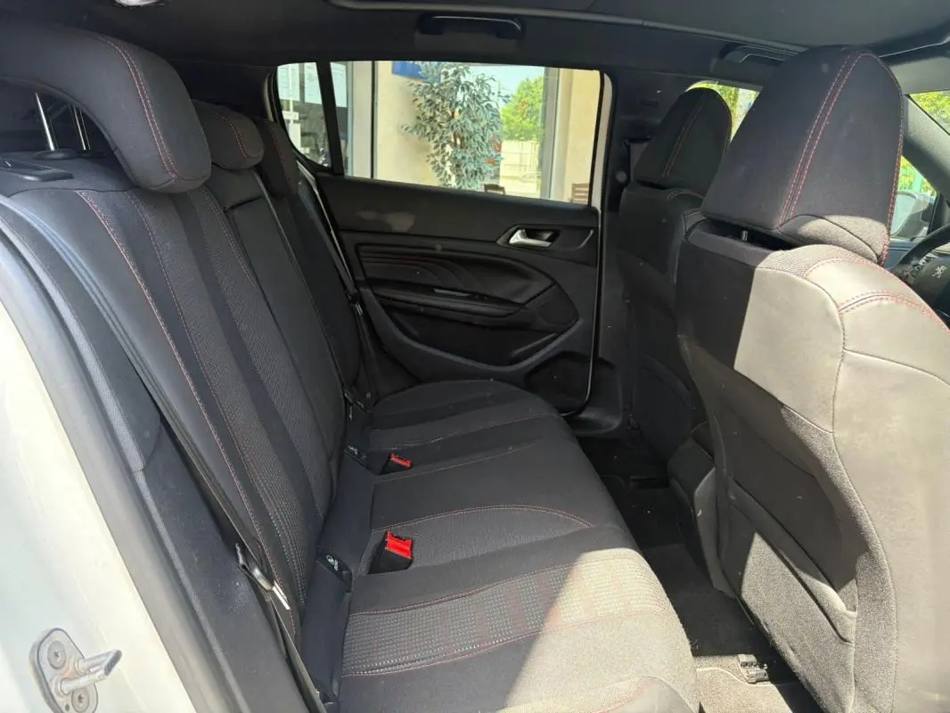 Vue intérieure côté droit sur la banquette arrière noire avec surpiqûres rouges d’une Peugeot 308 GT-Line blanche de 2017.