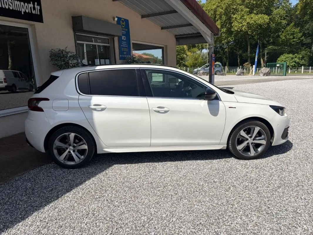 Peugeot 308 GT-Line blanche vue de profil côté gauche, avec jantes alliage et vitres teintées.