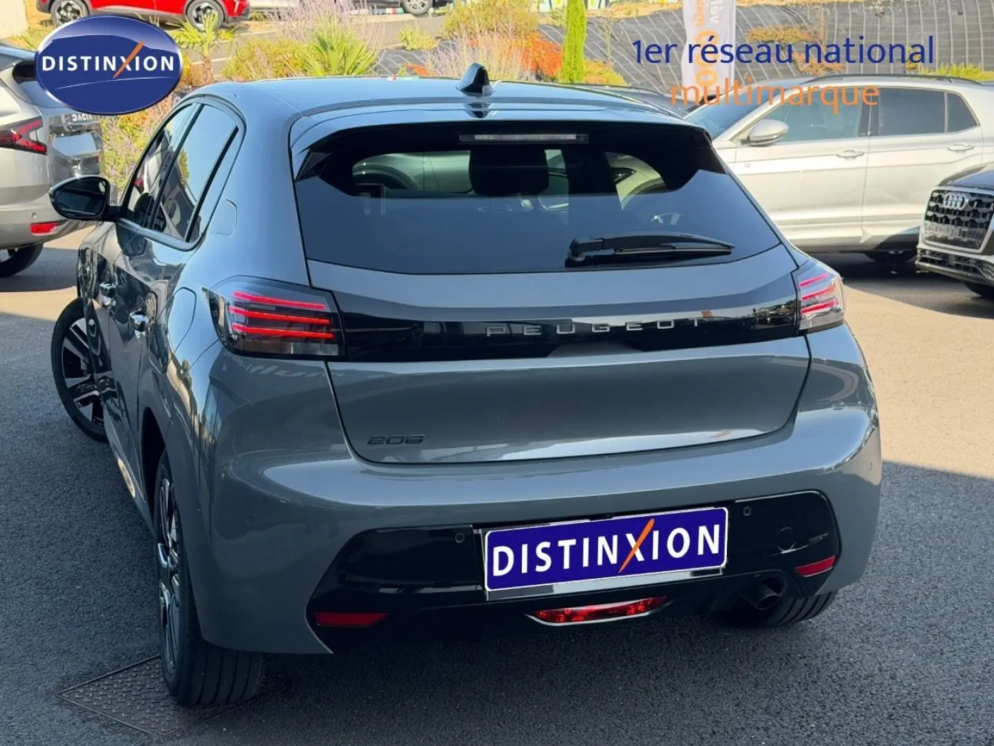 Vue 3/4 arrière d'une Peugeot 208 gris Artense avec feux arrière LED et jantes alu visibles en extérieur.