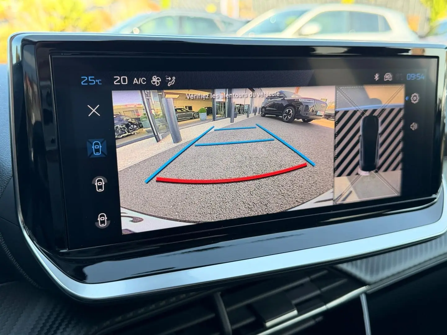 Écran tactile intérieur montrant la caméra de recul et l’aide au stationnement du Peugeot 208 gris Artense.