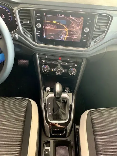 Vue rapprochée de la console centrale du Volkswagen T-Roc blanc 2021, avec écran GPS et levier de boîte automatique.