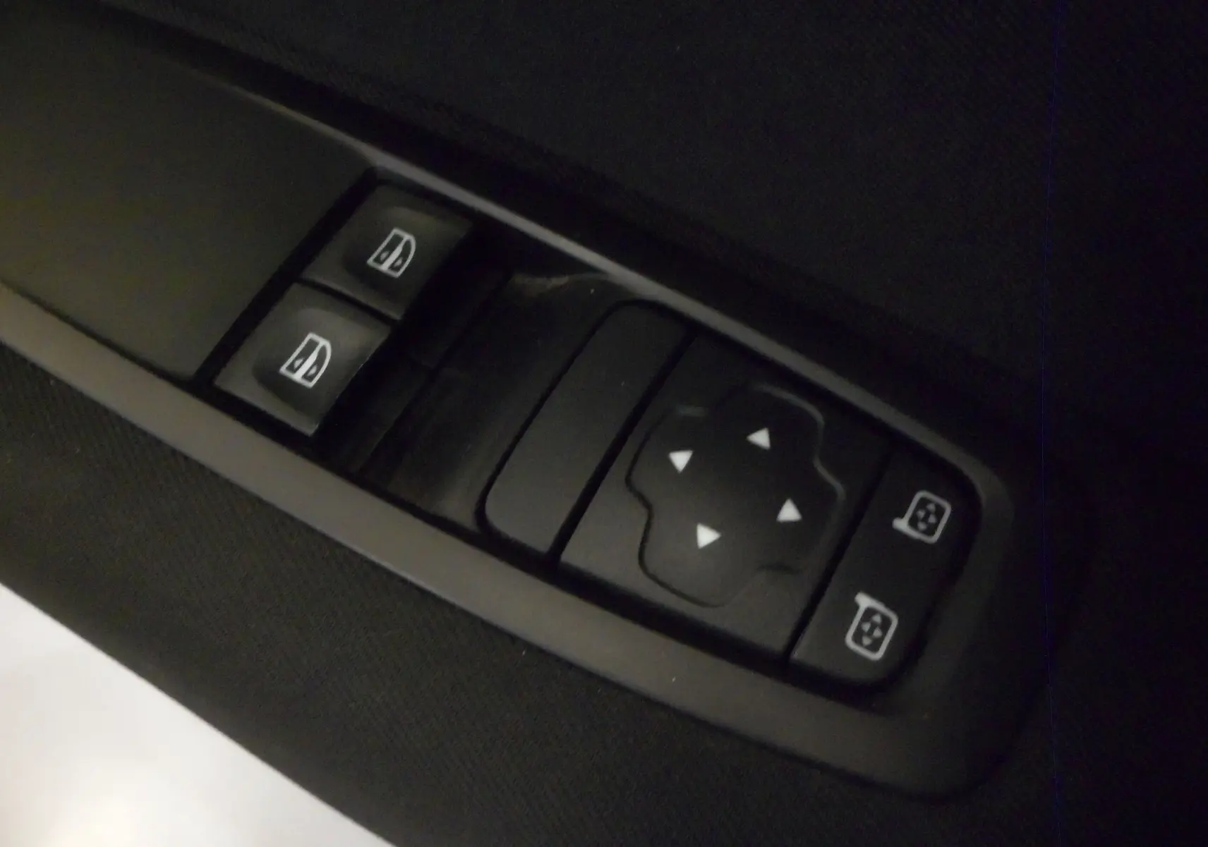 Gros plan sur les commandes électriques des vitres et rétroviseurs d'une Renault Mégane IV brun cappuccino, version TCe 100 CH LIFE.