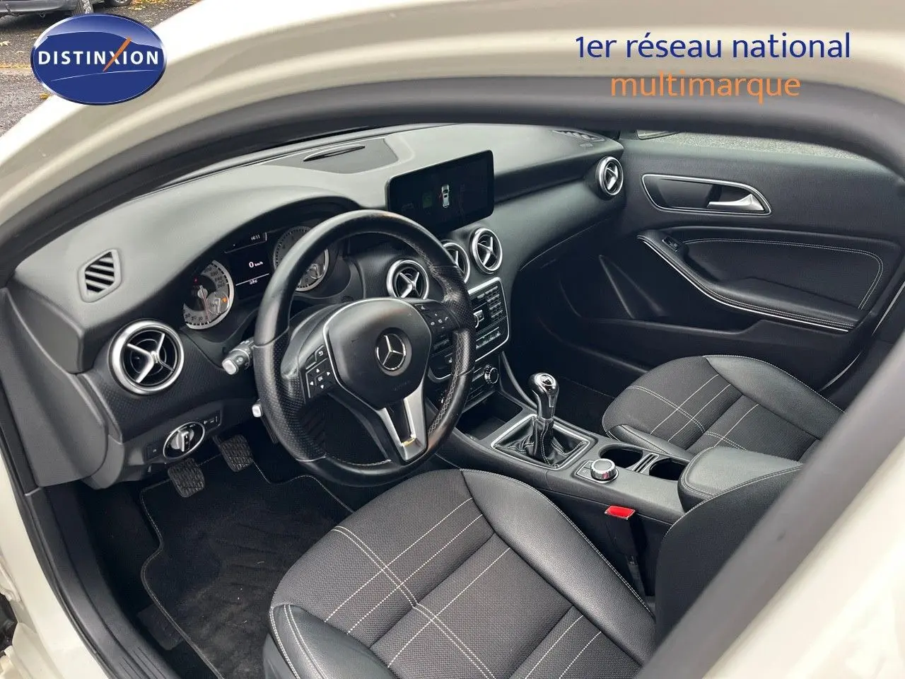 Intérieur noir de la Mercedes Classe A 180 Sensation 2013, vue côté conducteur avec volant et boîte manuelle visibles.