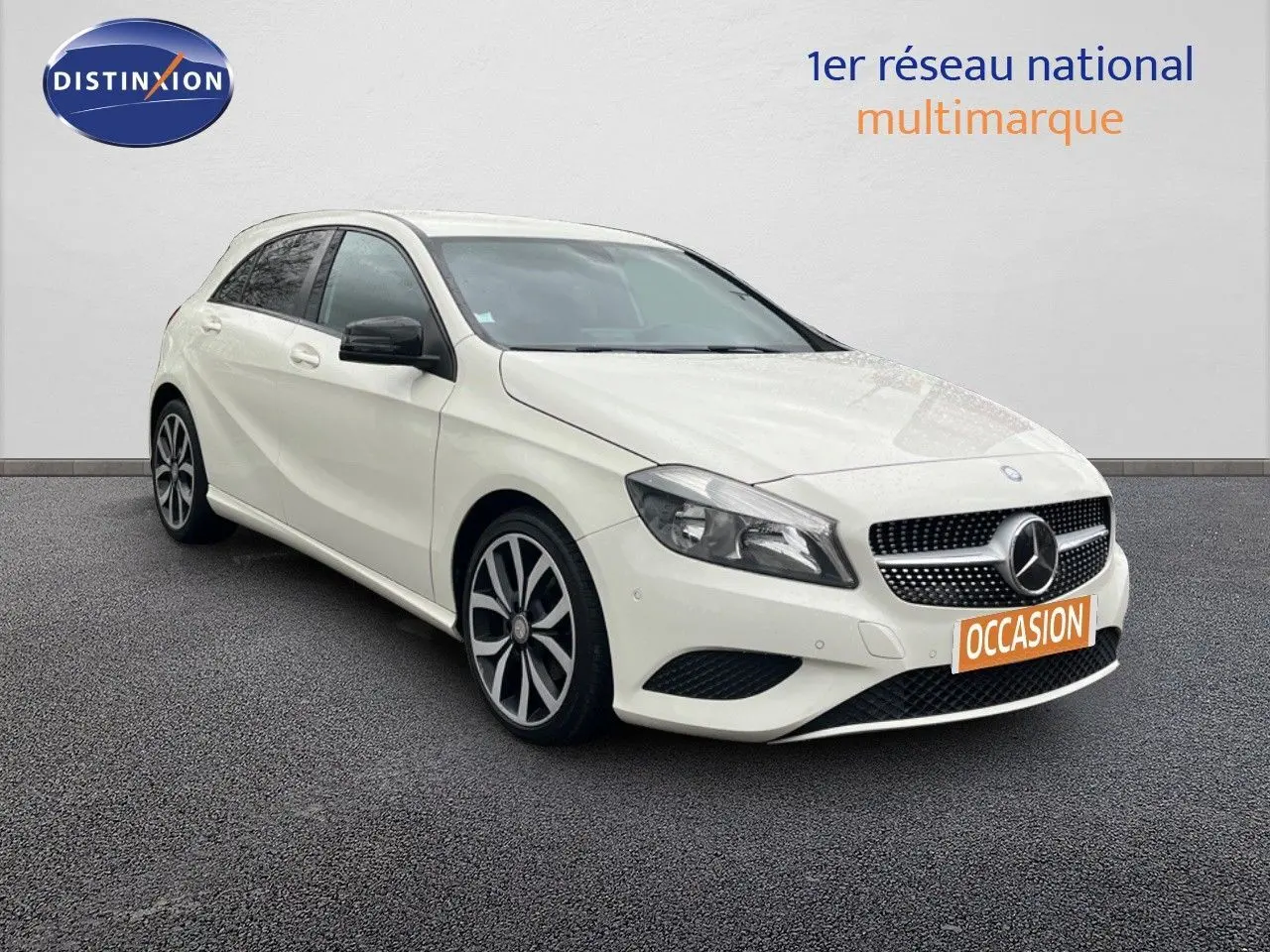 Mercedes Classe A 180 Sensation blanche vue en 3/4 avant droit avec jantes alliage distinctives et calandre étoile.