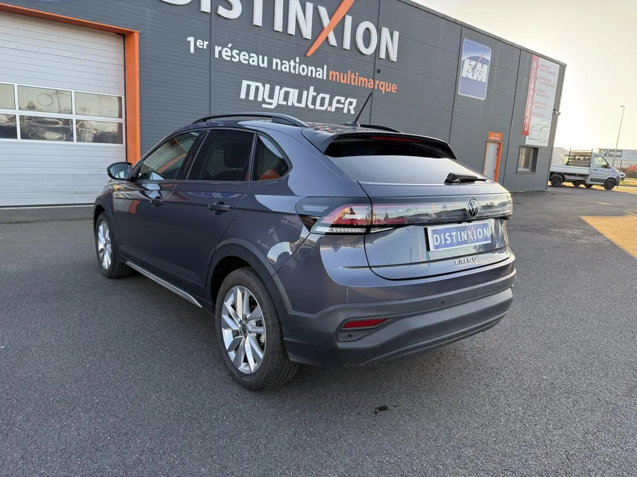Vue 3/4 arrière droite d’un Volkswagen Taigo gris INC avec jantes alliage 17 pouces et vitres arrière surteintées.