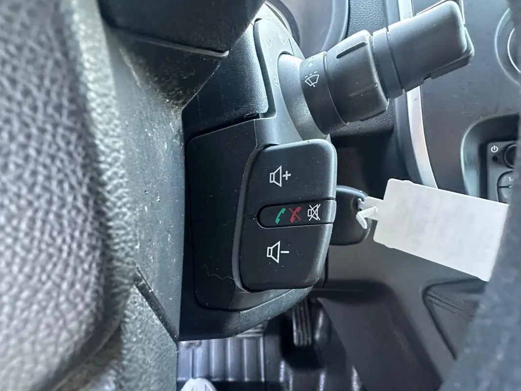 Gros plan sur les commandes au volant du Renault Kangoo Express blanc 2020, avec boutons de volume et appel.