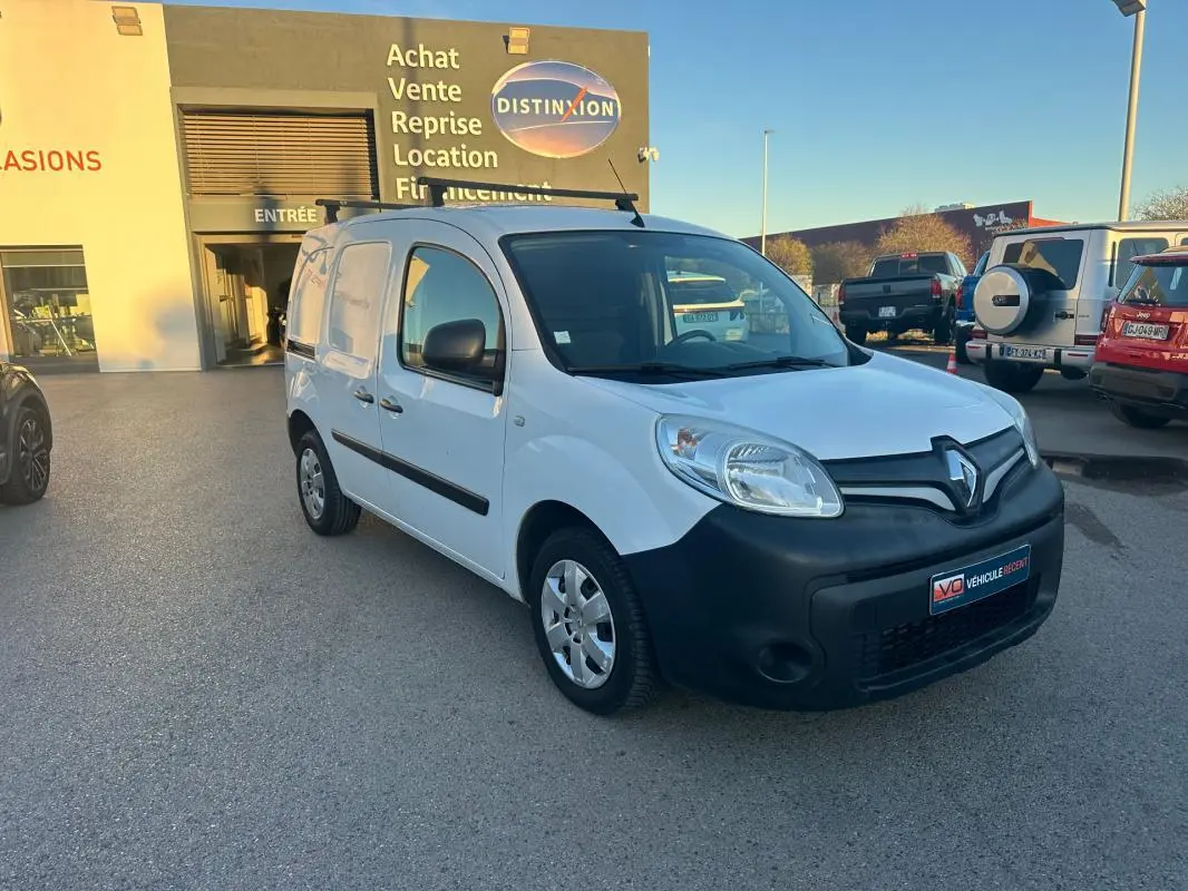 Renault Kangoo Express blanc en 3/4 avant droit avec pare-chocs noir et porte latérale visible sur parking.