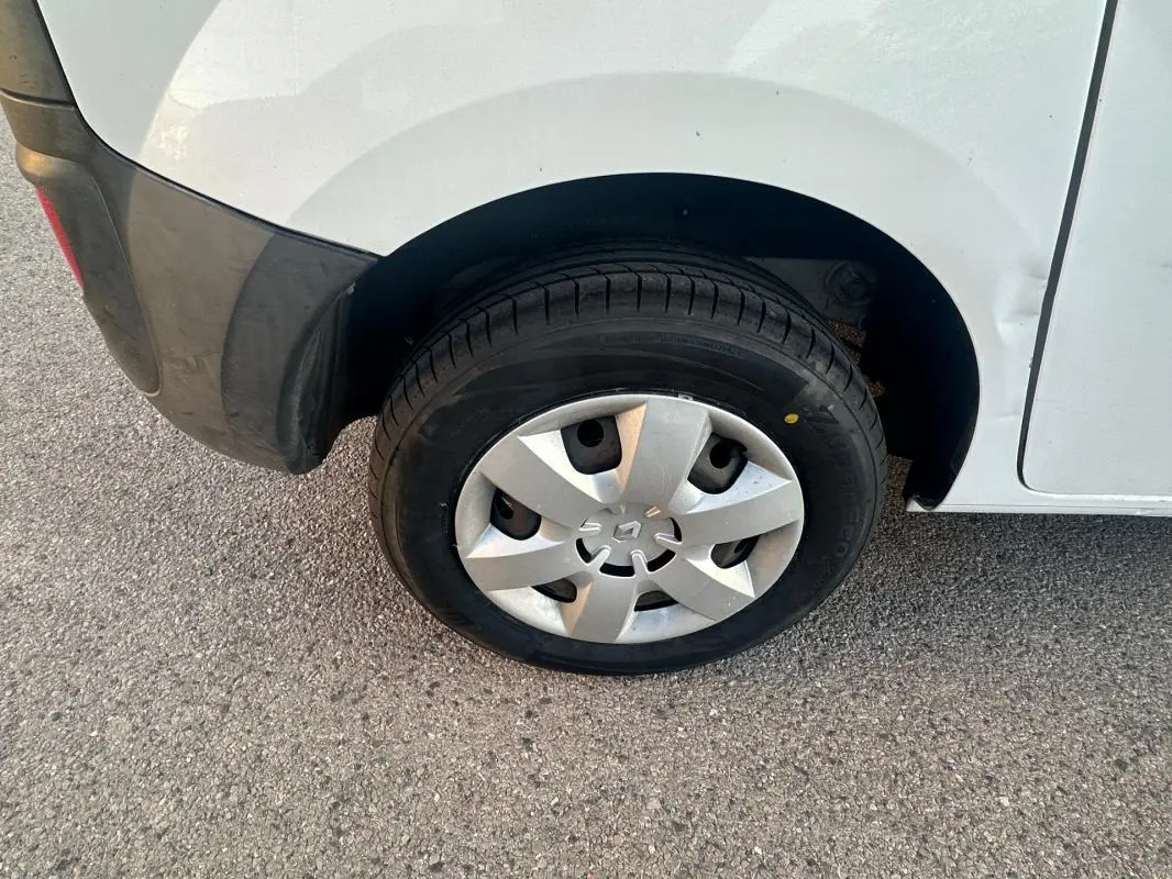 Gros plan sur la roue arrière droite d'un Renault Kangoo Express blanc avec enjoliveur et pare-chocs noir.